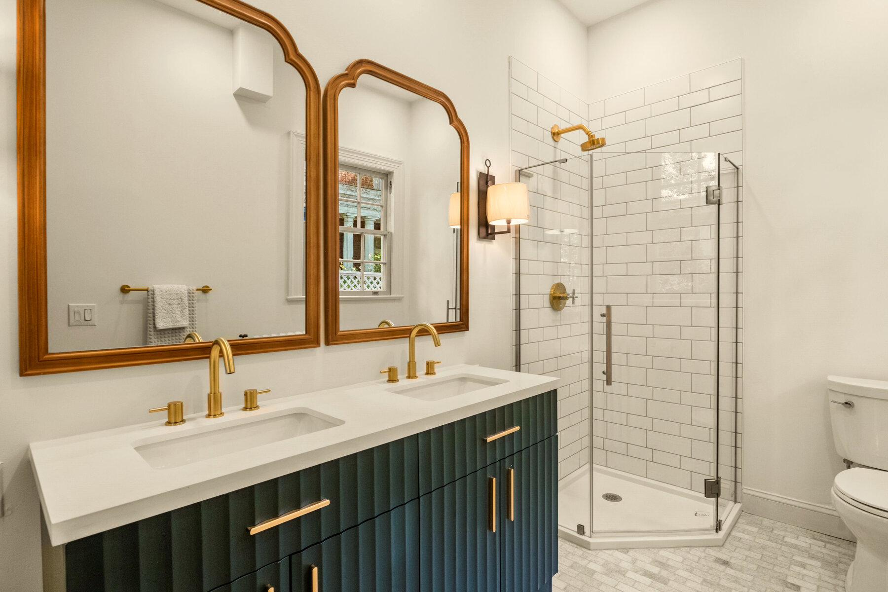 Primary bath with teal vanity and brass fixtures